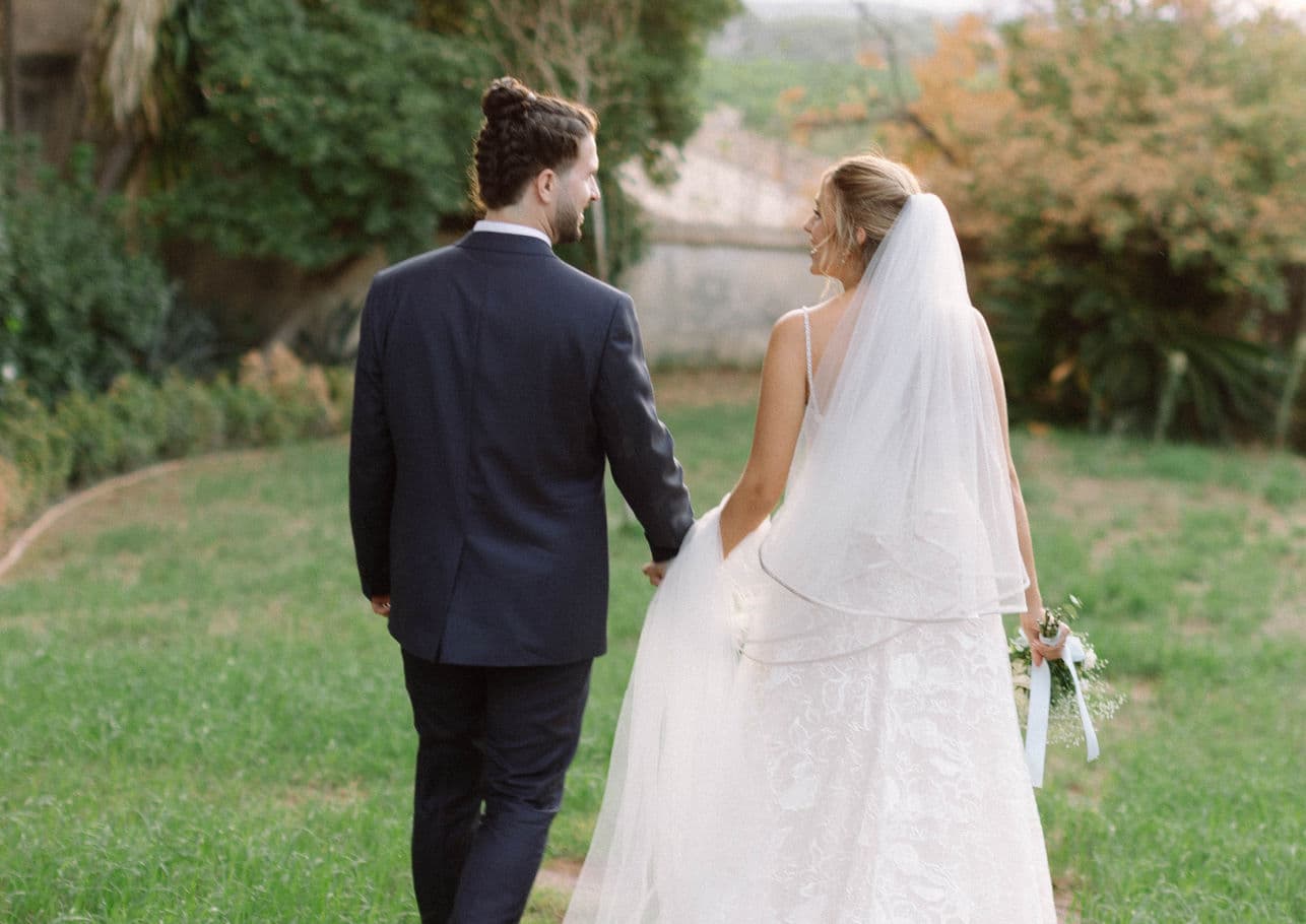 Pareja recién casada caminando de espaldas por la finca La Torre by Bonho